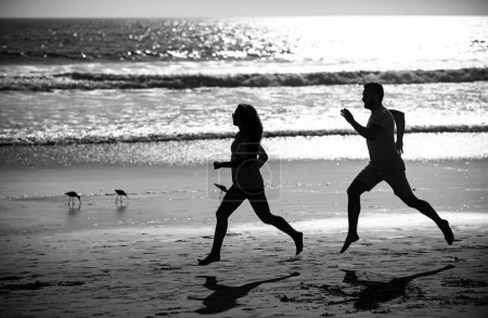 Photo for Sport runners jogging on beach working out. Fitness exercise outdoors concept. Couple running on beach - Royalty Free Image