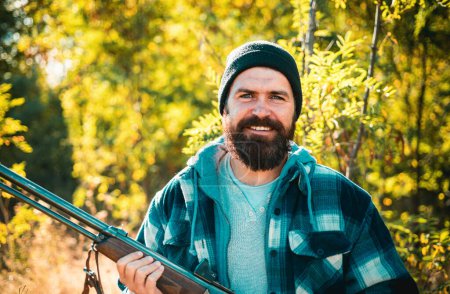 Photo for Bearded hunter man holding gun and walking in forest. Hunter with shotgun gun on hunt. Hunting in spring forest - Royalty Free Image