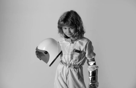 Téléchargez les photos : Le petit enfant veut voler dans l'espace avec un casque d'astronaute. Espace de copie. Innovation et inspiration pour enfants - en image libre de droit