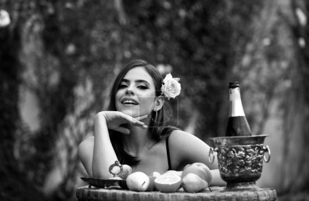 Photo for Beautiful happy smiling sexy girl in garden eating tropical fruit, summer vacation - Royalty Free Image