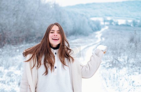 Foto de Mujer feliz invierno sobre fondo nevado. Al aire libre. Joven bella alegre divirtiéndose en Winter Park. Nieve de invierno. Invierno mujer ropa - Imagen libre de derechos