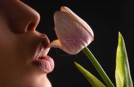 Foto de Sexy lesbian foreplay. Lip with tulip flower. Blowjob and kiss. Sexy female mouth and spring flower. Oral sex concept - Imagen libre de derechos