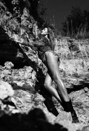 Foto de Mujer sexy cuerpo en cantera rocas al aire libre. Hermosa mujer joven en vestido de moda al aire libre. Sexy y sensual modelo femenino - Imagen libre de derechos