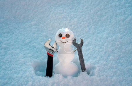 Foto de Construcción y reparación. Snowman constructor con herramientas de reparación. Felices fiestas y celebraciones - Imagen libre de derechos