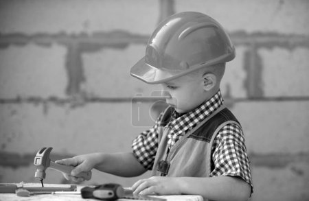 Foto de Child in helmet is construction worker. Foreman kid work in the hard hat making repairs. Childhood development. Little builder engineer. Improve your childhood - Imagen libre de derechos