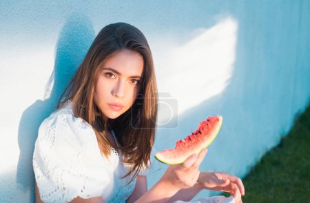 Téléchargez les photos : Jeune fille mangeant pastèque, fruits tropicaux d'été. Beauté femme visage - en image libre de droit