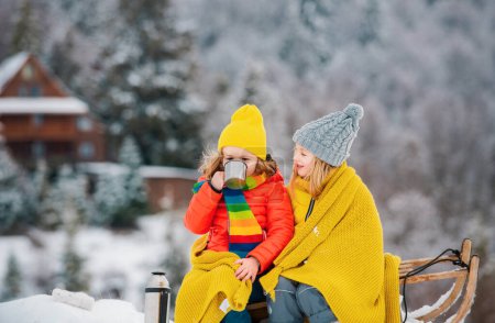 Foto de Divertido chico y chica divirtiéndose con un trineo en invierno. Lindos niños jugando en la nieve. Actividades de invierno para niños - Imagen libre de derechos