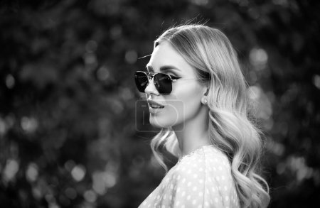 Foto de Retrato de una mujer joven en gafas de sol, primer plano cara de mujer hermosa al aire libre. Modelo femenino alegre - Imagen libre de derechos
