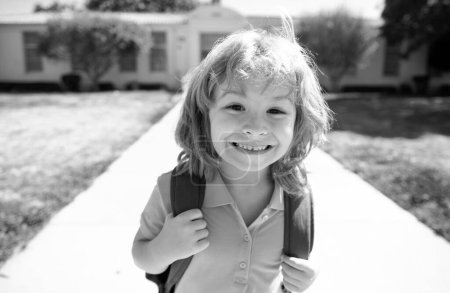 Foto de Cara divertida del chico de la escuela. De vuelta a la escuela. Retrato de niño emocionado con mochila corriendo e yendo a la escuela - Imagen libre de derechos