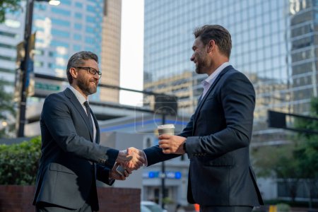 Photo for American businessman shaking hands with partner. Businessmen in suit shaking hands outdoors. Handshake between two businessmen. wo business men had business contacts. Business strategy - Royalty Free Image