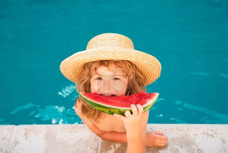 Foto de Retrato de niño comiendo una rebanada de sandía junto a una piscina divirtiéndose jugando vacaciones de verano, al aire libre. Vacaciones activas de estilo de vida - Imagen libre de derechos