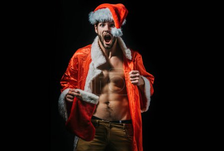 Photo for Christmas sexy santa man. Amazed men in santa hat. Muscle man at xmas. Santa with muscular body. Christmas party and sex games. Handsome sexy santa claus guy on black background - Royalty Free Image