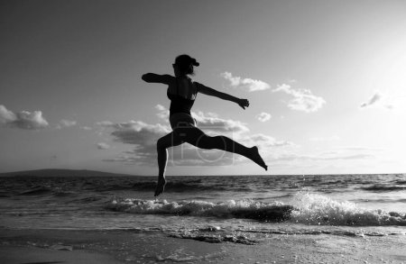 Foto de Una mujer corriendo en la playa. Belleza mujer sexy correr en la playa del mar - Imagen libre de derechos
