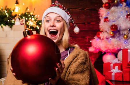 Téléchargez les photos : Belle femme souriante souhaite Joyeux Noël. Femme d'hiver portant le chapeau rouge de Père Noël. Vacances d'hiver et concept de personnes - en image libre de droit