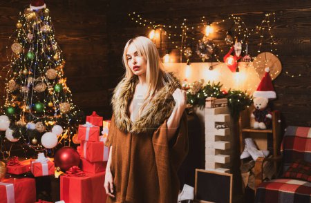 Photo for Merry Christmas. Woman in Christmas dress near the Christmas tree. Beautiful young woman wish you happy new year - Royalty Free Image