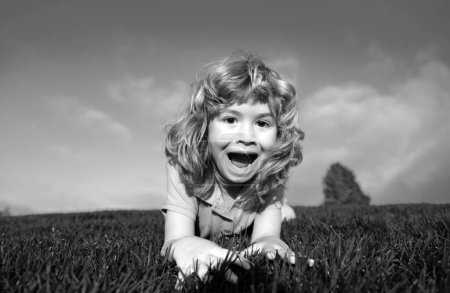 Foto de Retrato de un chico divertido emocionado en el parque. Divertido niño jugando en el jardín patio trasero riendo y divirtiéndose. Actividad al aire libre de verano para niños. Cara de expresión - Imagen libre de derechos