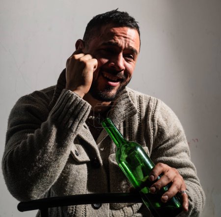 Foto de Un borracho bebiendo vino. Tipo deprimido con botella de alcohol, triste e infeliz - Imagen libre de derechos