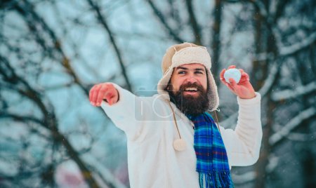 Photo for Christmas preparation - man with snowball. Winter scene on white snow background - happy man playing with snowball against white winter background - Royalty Free Image