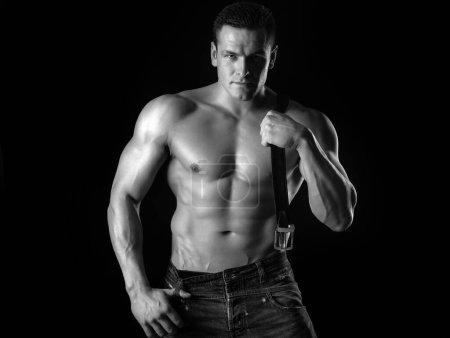 Photo for Brutal man with muscular body. Sexy young male holding leather belt. Bad guy - Royalty Free Image
