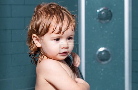 Téléchargez les photos : Enfant dans une baignoire. Bain bébé. Enfant heureux avec mousse de savon sur la tête - en image libre de droit