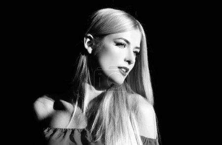 Téléchargez les photos : Portrait de femme blonde élégante avec lumière sur fond noir. Belle visage féminin dans l'obscurité - en image libre de droit