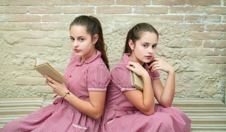 Photo for Teenagers young schoolgirls with book on blackboard at school. Portrait of a teens female students - Royalty Free Image