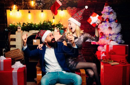 Foto de Tiempo de Navidad para amigos felices. Las chicas borrachas celebran el Año Nuevo. Mujer sexy y hombre guapo con vestido de Santa - Imagen libre de derechos