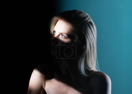 Photo for Sensual girl face in shadow. Stylish sexy woman on a gray background. Sensual young model on black studio. Woman eyes in shadow - Royalty Free Image
