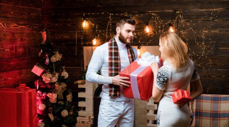 Téléchargez les photos : Nouvel an vêtements de mode. Femme et homme se font des cadeaux. Couple de Noël amoureux - en image libre de droit