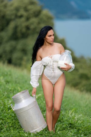 Photo for Sexy Milk farm. Beauty romantic Sexy girl drink milk from bottle outdoors. Sexy Model drink Milk at Alpine meadow. Fresh milking concept. Sexy female farmer - Royalty Free Image