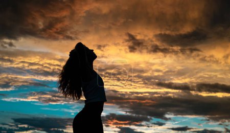 Téléchargez les photos : Jeune femme dansant en été coucher de soleil ciel en plein air. Style de liberté du peuple. - en image libre de droit
