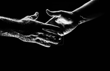Téléchargez les photos : Handshake. Men holding hands isolated on black. Connection and human relations. Male hands rescue. Friendly handshake, friends greeting, friendship. Rescue, helping gesture or hands. Helping hand - en image libre de droit