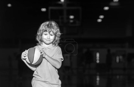 Téléchargez les photos : Enfant jouant au basket à l'école. Activité et sport pour les enfants - en image libre de droit