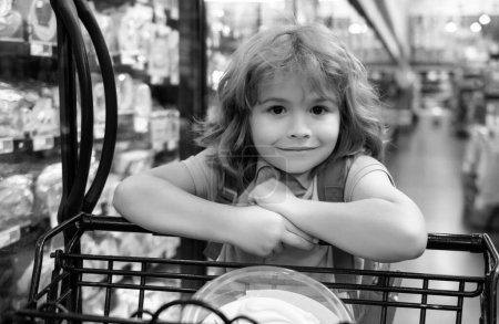 Téléchargez les photos : Enfant avec panier dans une épicerie - en image libre de droit