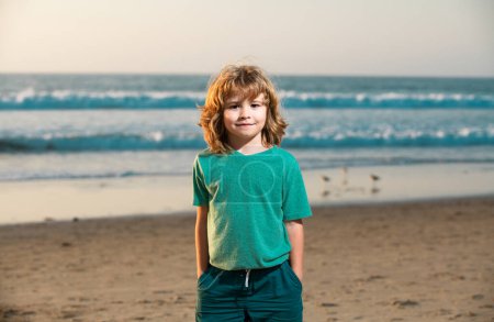 Foto de Niño en camiseta caminando en la playa de verano - Imagen libre de derechos