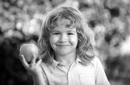 Téléchargez les photos : Enfant mangeant des pommes fruits en plein air automne nature sain en plein air - en image libre de droit