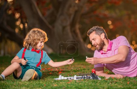 Foto de Familia feliz al aire libre. Padre e hijo jugando ajedrez en otoño jardín de otoño. Niño inteligente, niños inteligentes - Imagen libre de derechos