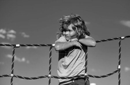 Téléchargez les photos : Portrait d'enfant garçon mignon faisant de l'escalade dans le fond de jeu - en image libre de droit