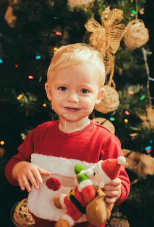 Téléchargez les photos : Joyeux Noël et bonne année. Jouets de Noël et bonne enfance. L'enfant garçon riant et appréciant le cadeau. rêve de Noël
. - en image libre de droit