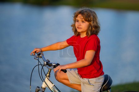 Photo for Little kid boy ride a bicycle in the park. Kid cycling on bicycle. Happy smiling child riding a bike. Boy start to ride a bicycle. Sporty kid bike riding on bikeway. Kids bicycle - Royalty Free Image