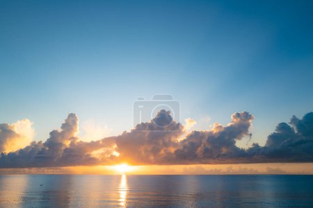 Téléchargez les photos : Ciel nuageux au coucher du soleil sur la mer, lever du soleil sur la plage océanique. Paysage au coucher du soleil dans le ciel après le coucher du soleil. Lever de soleil avec des nuages de différentes couleurs contre le ciel et la mer - en image libre de droit
