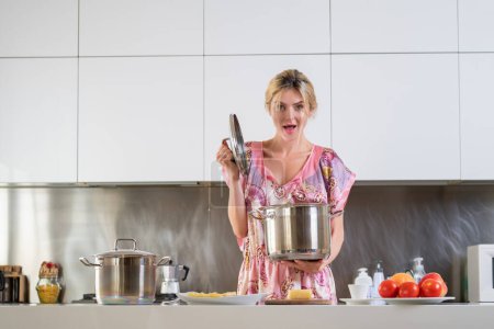 Téléchargez les photos : Cuisine sexy. Femme avec cuisinière dans une cuisine. Femme au foyer sexy le matin. Travaux ménagers sensuels dans une cuisine. Femme au foyer sexy dans une cuisine - en image libre de droit