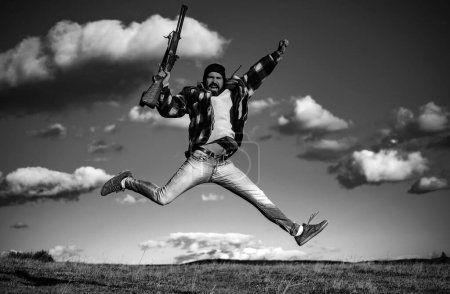 Foto de Hunter con escopeta a la caza. Cazador loco en el fondo del cielo - Imagen libre de derechos