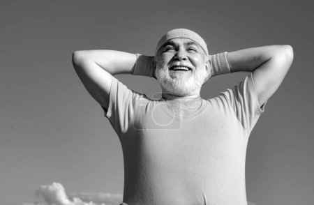 Photo for Freedom retirement concept. Elderly man practicing sports on blue sky background. Healthy and sport. Healthcare cheerful lifestyle - Royalty Free Image