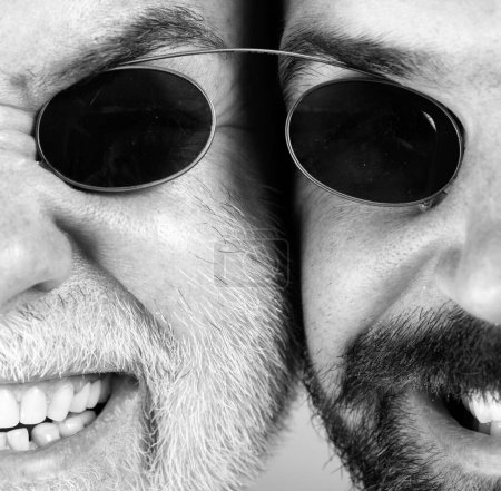 Photo for Glasses for men. Two Beardeds middle-aged mans wearing glasses looking at camera with a serious expression. Glasses concept. Senior man with son - Royalty Free Image