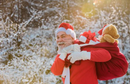 Téléchargez les photos : Père Noël livrer des cadeaux. Père Noël dans la montagne enneigée d'hiver. Nouvel An et Noël arrive - en image libre de droit