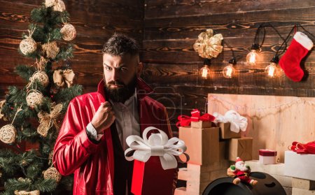 Téléchargez les photos : Hipster Santa Claus avec des cadeaux du Nouvel An. Accueil décoration de Noël et fond de nouvelle année. Santa claus tenir boîte cadeau de Noël rouge - en image libre de droit
