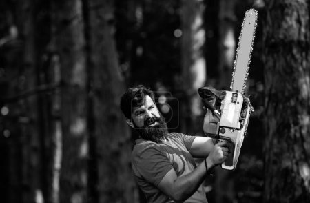 Photo for Man doing mans job. Agriculture and forestry theme. Handsome young man with axe near forest. The Lumberjack working in a forest. Firewood as a renewable energy source - Royalty Free Image