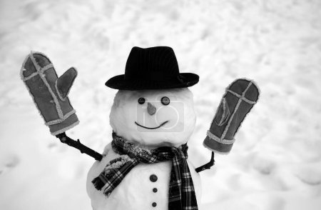 Foto de Divertidos muñecos de nieve. Feliz hombre de nieve sonriente en el soleado día de invierno. Hombres de nieve. Feliz muñeco de nieve de pie en invierno paisaje de Navidad. Descuentos venta Navidad - Imagen libre de derechos