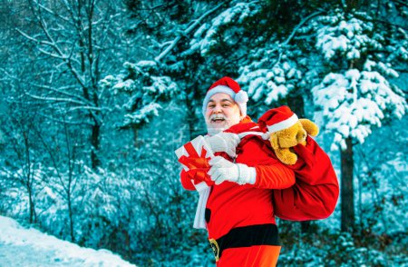 Photo for Winter landscape of forest and snow with santa claus. Santa Claus with big bag. New year Christmas concept. New year concept. Santa Claus with bag walking in winter - Royalty Free Image